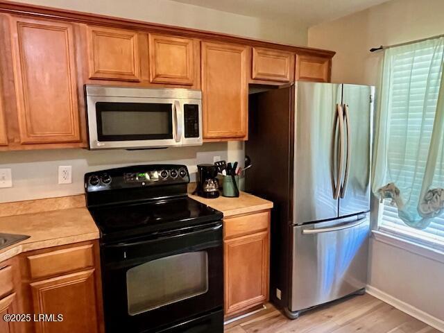 522 Candida Dr, Beaufort, SC 29906 - kitchen featuring appliances with stainless steel finishes, light countertops, brown cabinetry, light wood-style flooring, and baseboards