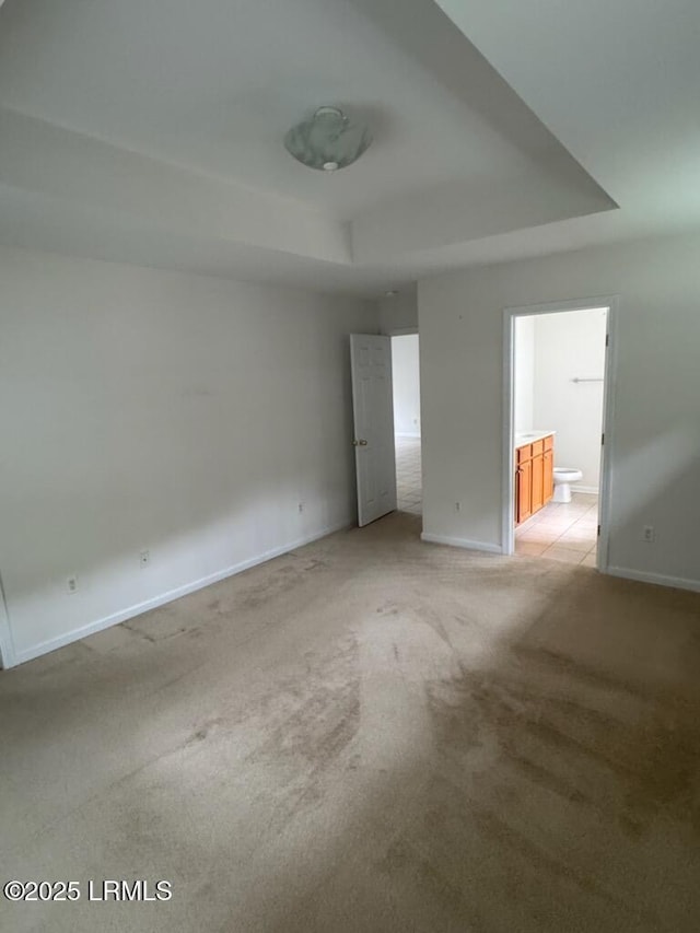 120 Crossings Blvd, Bluffton, SC 29910 - unfurnished bedroom with a tray ceiling, light carpet, baseboards, and ensuite bathroom