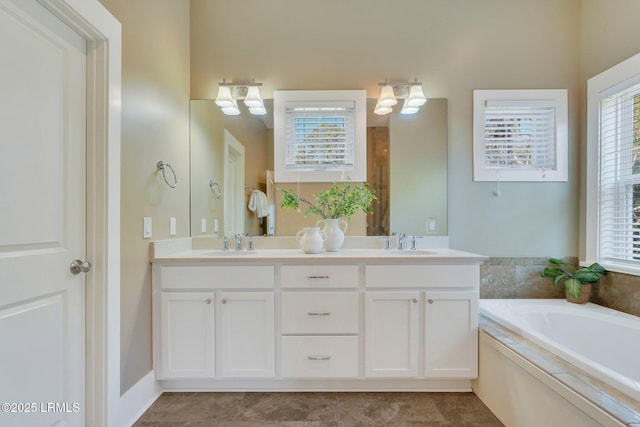 full bathroom with a garden tub, double vanity, and a sink