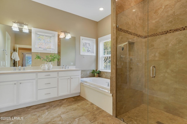 bathroom featuring a garden tub, a sink, a shower stall, and double vanity