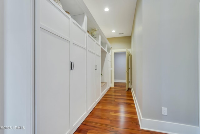 hall with dark wood-type flooring, recessed lighting, and baseboards