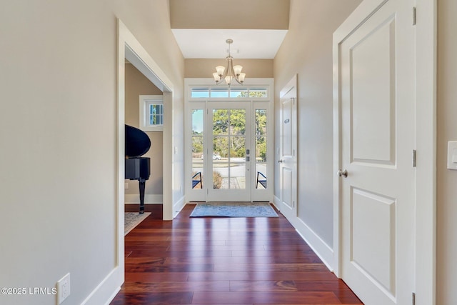 entrance foyer featuring baseboards, dark wood-style flooring, and a notable chandelier