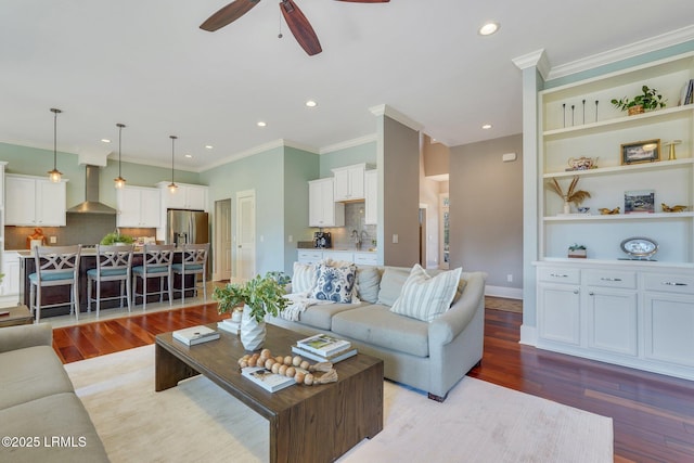 living area with light wood-type flooring, ornamental molding, a ceiling fan, and recessed lighting