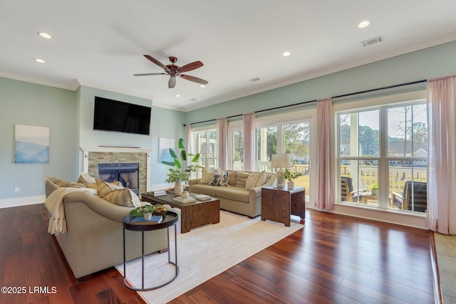 living area with crown molding, a fireplace, recessed lighting, wood finished floors, and baseboards