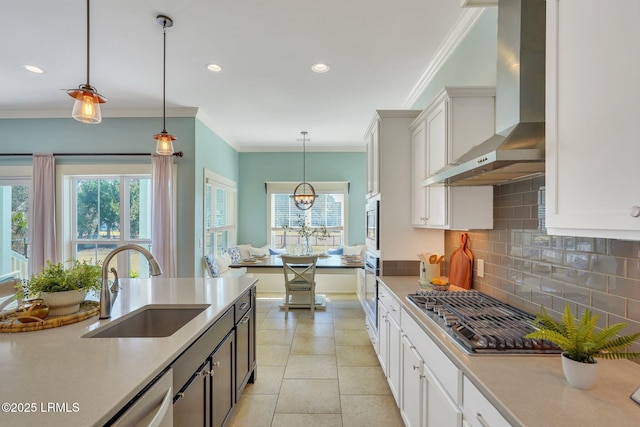 kitchen with wall chimney exhaust hood, a sink, stainless steel appliances, light countertops, and backsplash