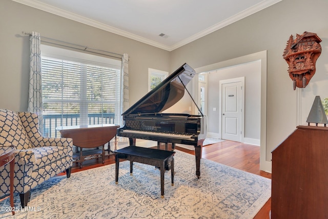 living area with ornamental molding, baseboards, and wood finished floors