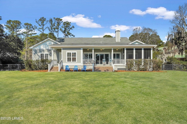 rear view of property featuring fence, a sunroom, a ceiling fan, a lawn, and a chimney