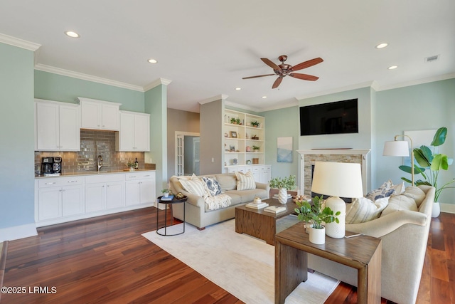 living area with a fireplace, visible vents, dark wood-type flooring, and recessed lighting