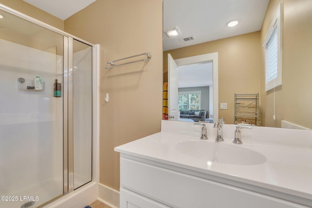 ensuite bathroom with ensuite bathroom, a stall shower, vanity, and visible vents