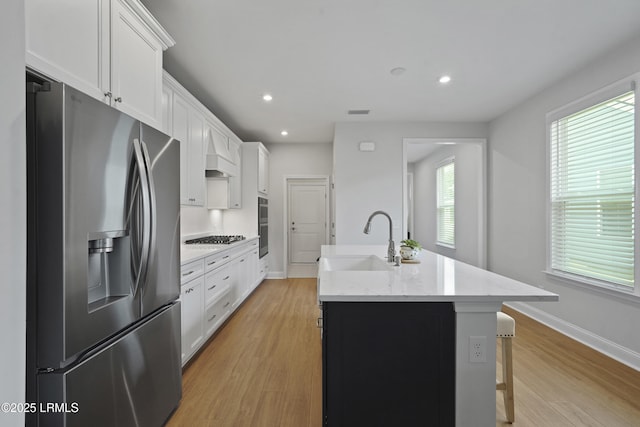 821 Aurora Way, Bluffton, SC 29909 - kitchen with stainless steel fridge, a sink, a kitchen island with sink, white cabinets, and light wood-style floors