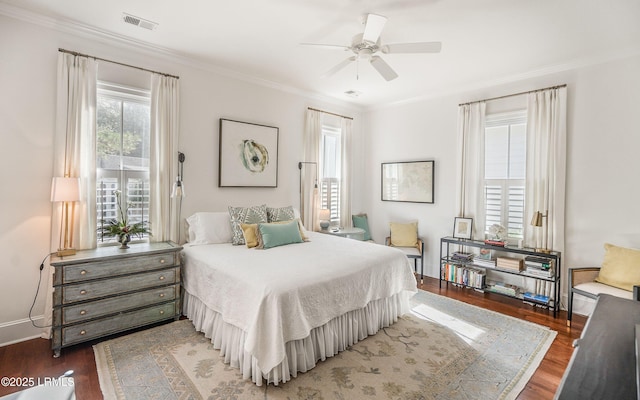 bedroom with ornamental molding and dark hardwood / wood-style floors