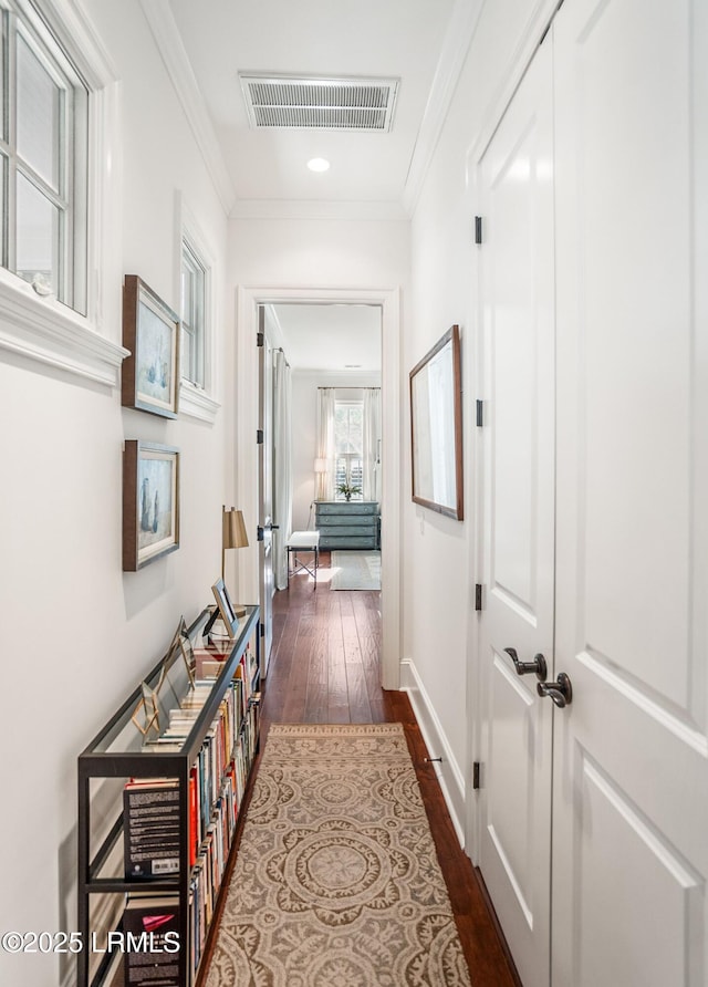 hallway with ornamental molding and dark wood-type flooring