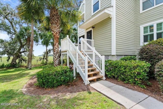 doorway to property featuring a wooden deck and a yard