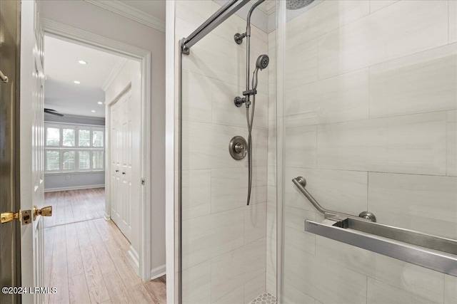 bathroom featuring crown molding, wood-type flooring, and an enclosed shower