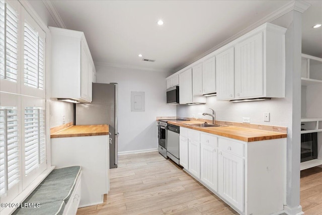 kitchen featuring wood counters, appliances with stainless steel finishes, sink, and white cabinets