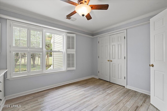 unfurnished bedroom featuring ornamental molding, light hardwood / wood-style floors, ceiling fan, and a closet