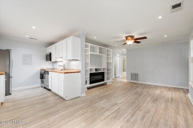 kitchen featuring stainless steel refrigerator, wood counters, white cabinetry, and crown molding