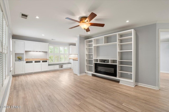 unfurnished living room with ornamental molding, ceiling fan, and light wood-type flooring