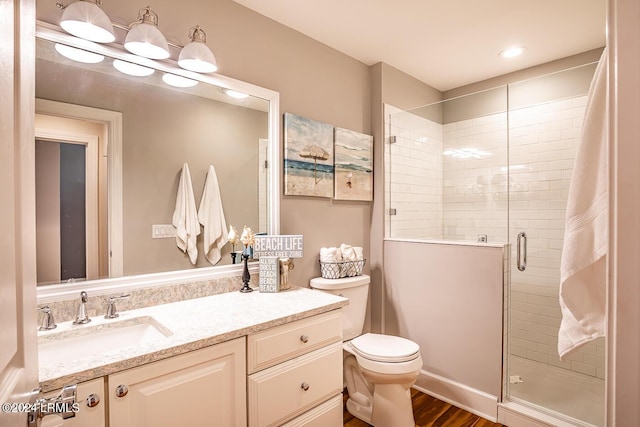 bathroom featuring vanity, hardwood / wood-style floors, toilet, and walk in shower