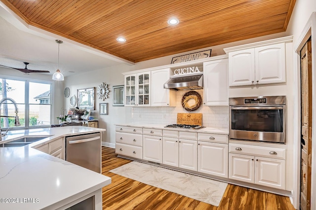 kitchen with appliances with stainless steel finishes, pendant lighting, sink, white cabinets, and wood ceiling