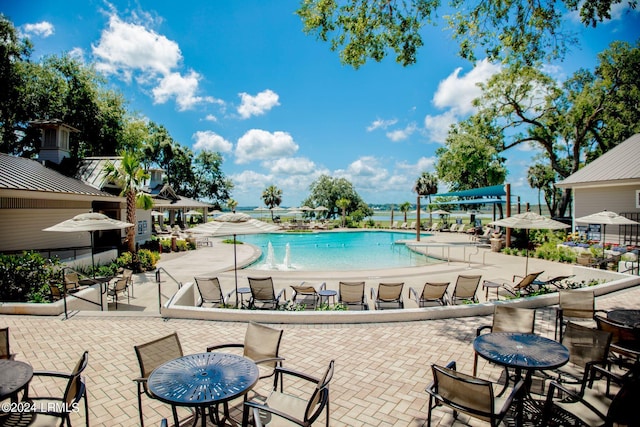 view of swimming pool with pool water feature and a patio area