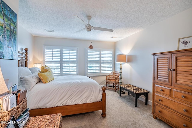 carpeted bedroom with ceiling fan and a textured ceiling