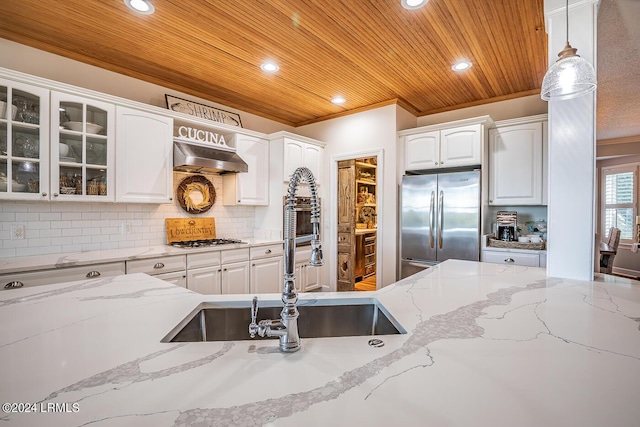 kitchen with appliances with stainless steel finishes, pendant lighting, white cabinetry, sink, and wooden ceiling