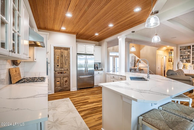 kitchen featuring sink, wood ceiling, white cabinetry, stainless steel appliances, and decorative light fixtures