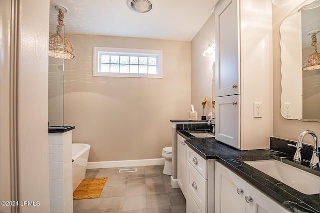 bathroom featuring a tub to relax in, toilet, tile patterned flooring, and vanity