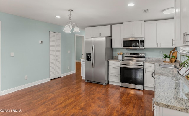 kitchen featuring sink, hanging light fixtures, stainless steel appliances, light stone countertops, and white cabinets