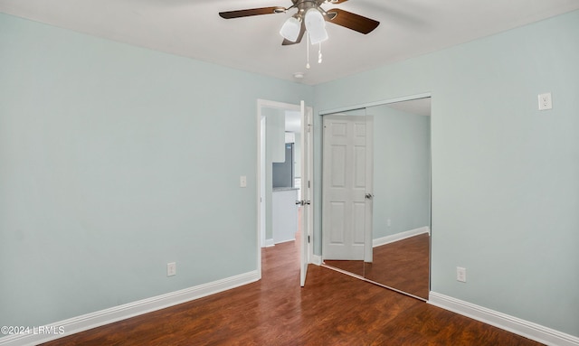 unfurnished bedroom with dark hardwood / wood-style floors, ceiling fan, and a closet