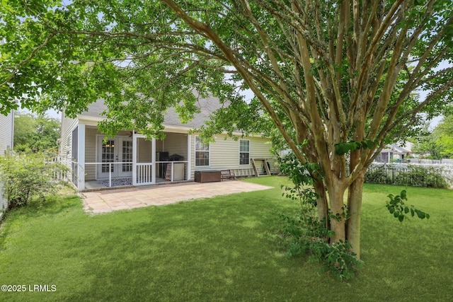 view of yard featuring french doors, fence, and a patio