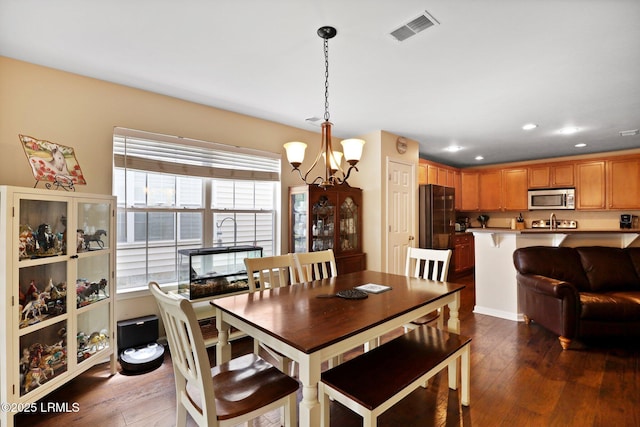 dining room with dark wood-style flooring, visible vents, an inviting chandelier, and recessed lighting