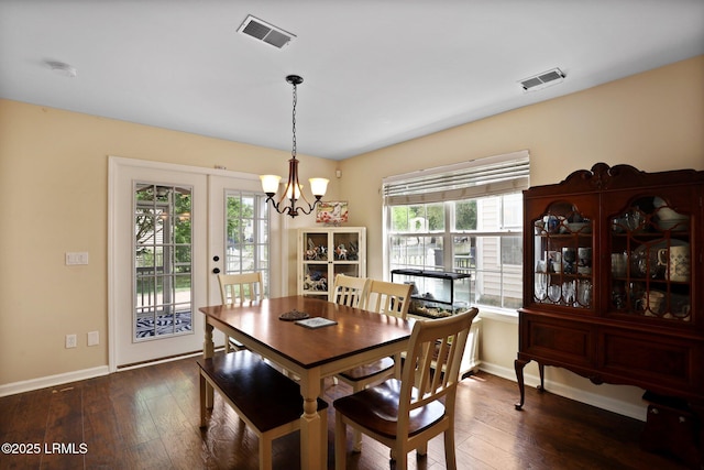 dining area featuring an inviting chandelier, dark wood-type flooring, and visible vents