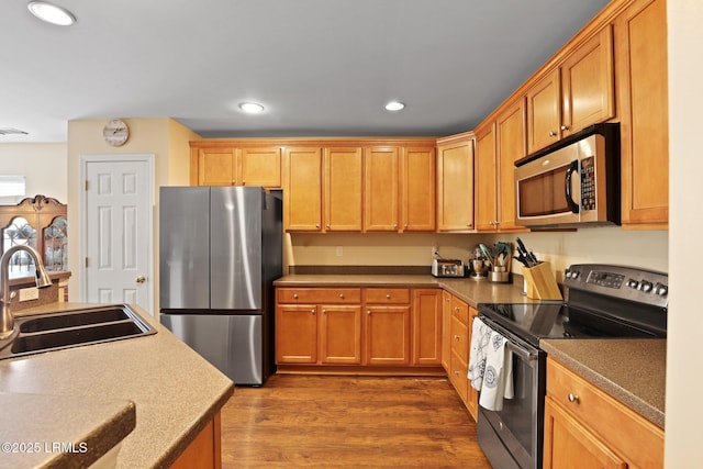 kitchen featuring dark wood-style flooring, appliances with stainless steel finishes, a sink, and recessed lighting