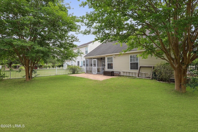 rear view of house featuring a patio area, a sunroom, fence, a yard, and a shingled roof