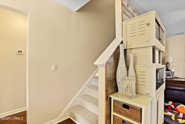 stairs with visible vents, baseboards, and wood finished floors