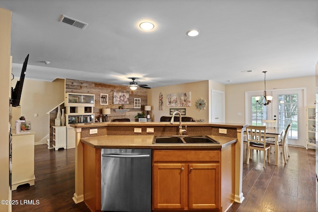 kitchen with a sink, an island with sink, ceiling fan with notable chandelier, open floor plan, and stainless steel dishwasher