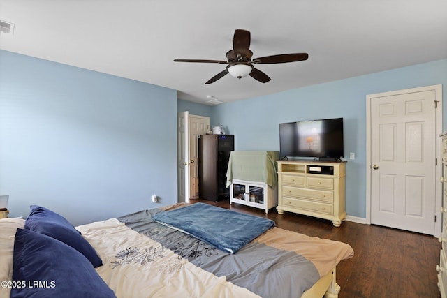 bedroom with baseboards, a ceiling fan, dark wood finished floors, and visible vents
