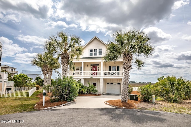 raised beach house featuring a porch and a garage