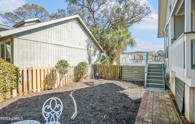 view of yard with a fenced backyard, stairway, and a deck