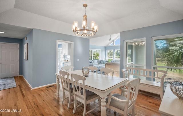 dining space featuring lofted ceiling, light wood-style floors, baseboards, and visible vents
