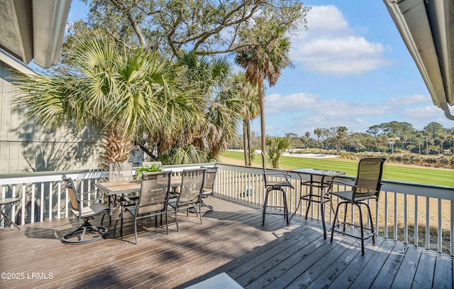 deck featuring outdoor dining space and a yard
