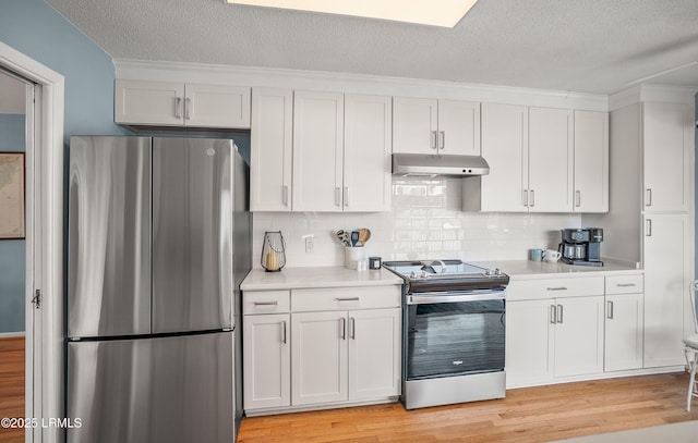 kitchen with light wood finished floors, stainless steel appliances, light countertops, white cabinetry, and under cabinet range hood