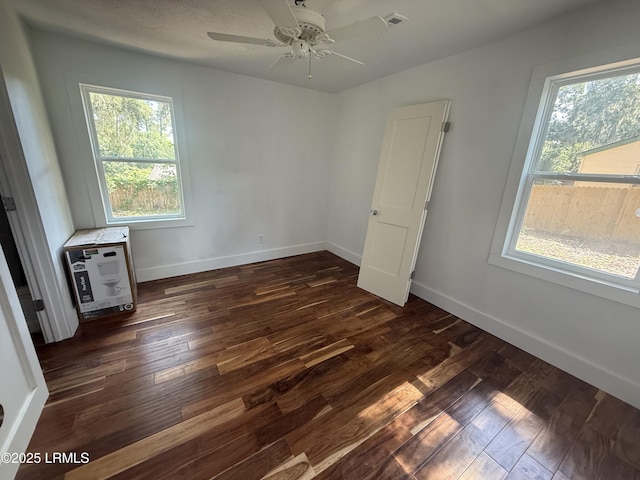 unfurnished bedroom featuring dark wood-style floors, baseboards, and ceiling fan