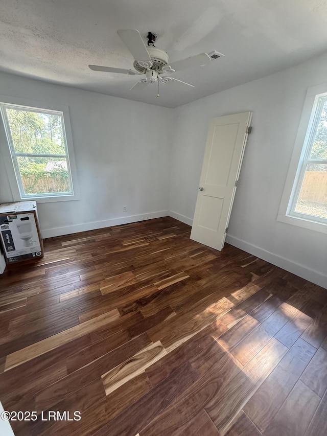 spare room with wood finished floors, ceiling fan, and baseboards