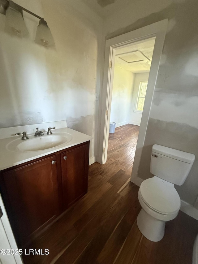 bathroom featuring wood finished floors, toilet, and vanity