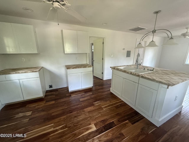 kitchen featuring a sink, a ceiling fan, dark wood finished floors, and white cabinets