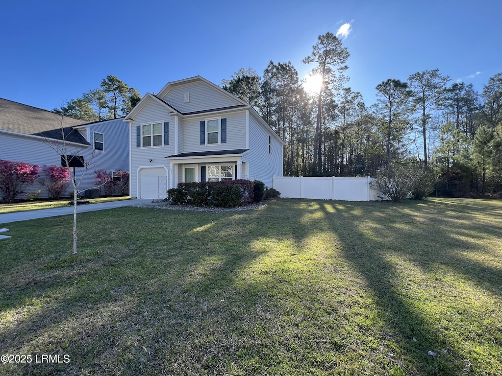 traditional home featuring a garage, driveway, fence, and a front lawn