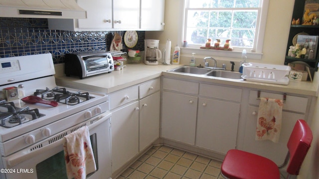 kitchen featuring white cabinetry, white gas stove, and range hood